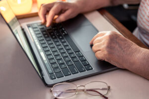 juros do empréstimo consignado podem cair, pessoa idosa utilizando notebook