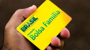 mão segurando cartão do novo bolsa família