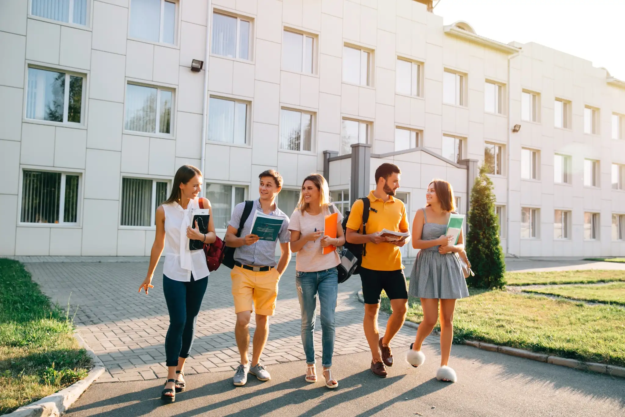 Grupo de estudantes caminhando pelo campus, simbolizando o aprendizado e a troca de experiências no programa Jovem Aprendiz.