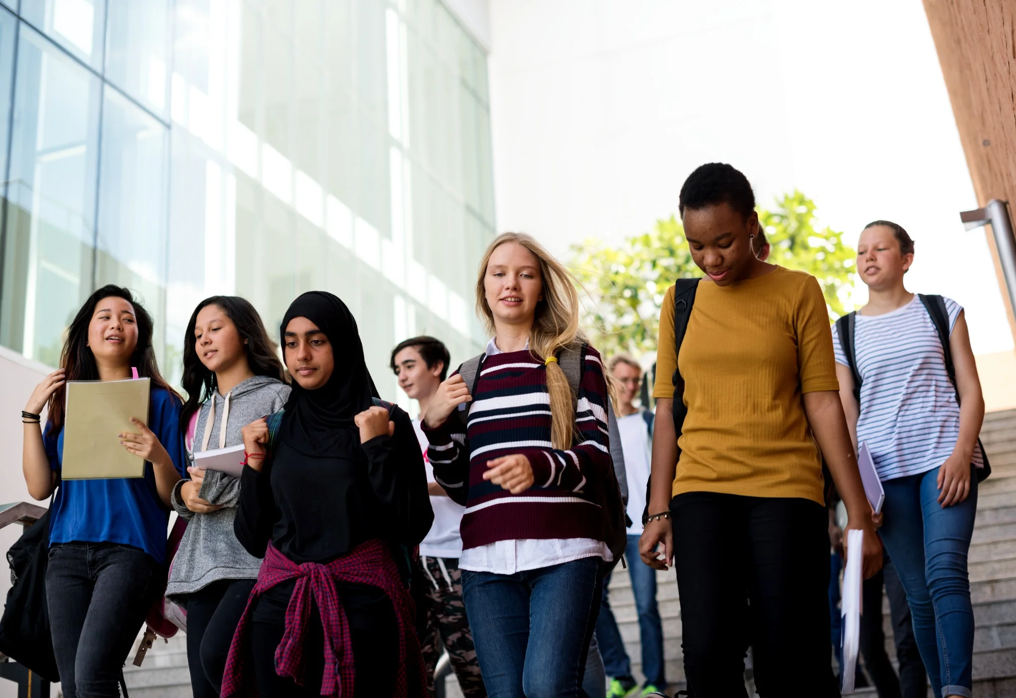 Grupo diversificado de estudantes caminhando juntos, refletindo a inclusão e as oportunidades oferecidas pelo programa Aprendiz BB.