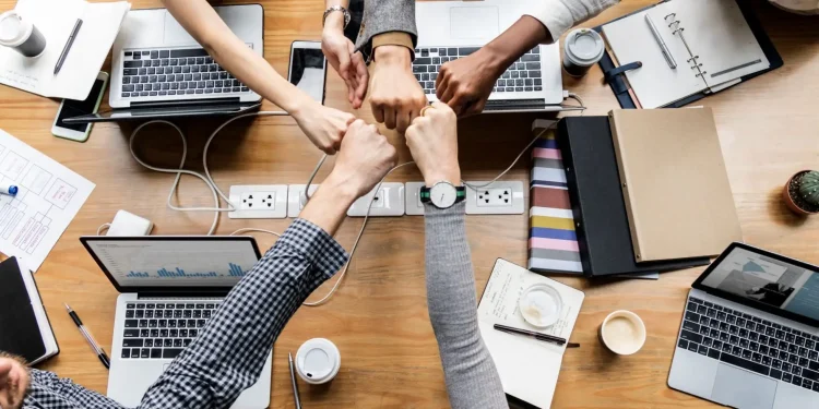 Equipe unida dando soquinho em um ambiente de trabalho colaborativo.