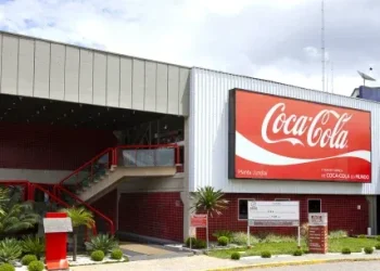 Fachada da planta da Coca-Cola com logo e escada de acesso.