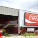 Fachada da planta da Coca-Cola com logo e escada de acesso.