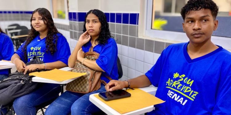 Jovens aprendizes do SENAI em sala de aula usando camisetas azuis do programa. Imagem: SENAI Amapá