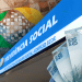 Imagem mostrando a fachada do INSS com notas de 100 reais, relacionada aos pagamentos do INSS em março de 2025.