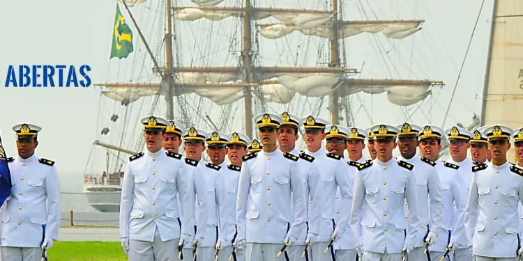 Oficiais da Marinha do Brasil em desfile com navio ao fundo.