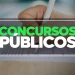 Pessoa escrevendo em uma folha de prova, representando concursos públicos.