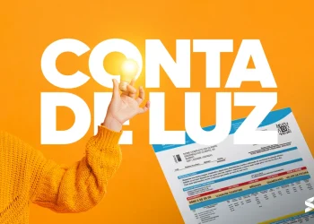 "Imagem de uma conta de luz com foco em uma lâmpada acesa em primeiro plano."