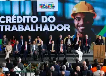 Evento de lançamento do programa Crédito do Trabalhador, com autoridades e público presente.