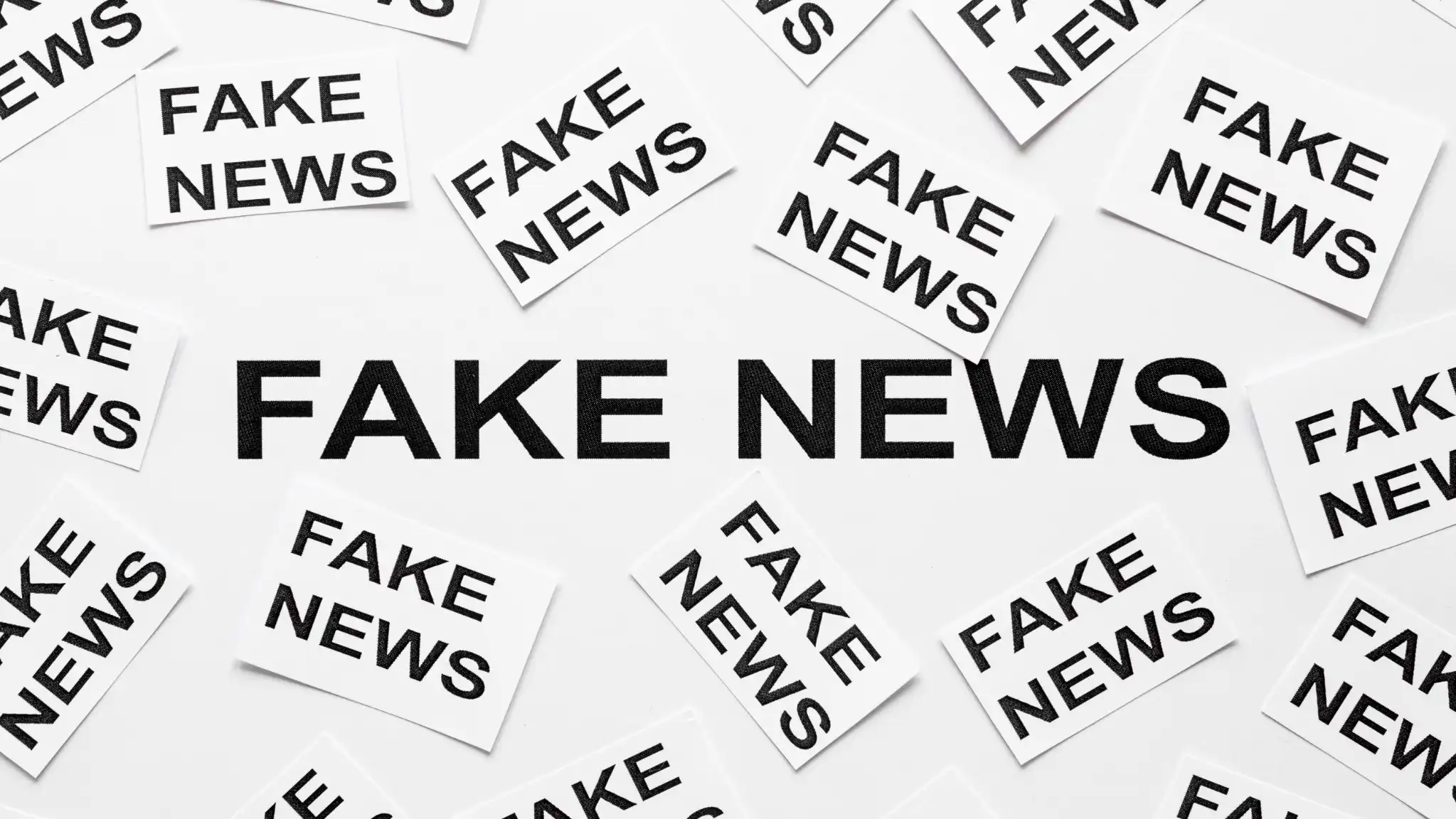 Imagem com várias etiquetas de 'FAKE NEWS' espalhadas, alertando para fraudes e desinformação, como em casos de concursos públicos falsos.