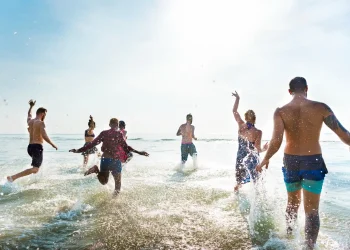 Grupo de amigos se divertindo no mar durante um dia ensolarado.