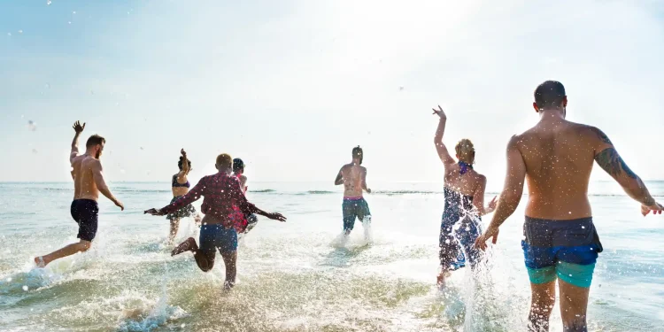 Grupo de amigos se divertindo no mar durante um dia ensolarado.