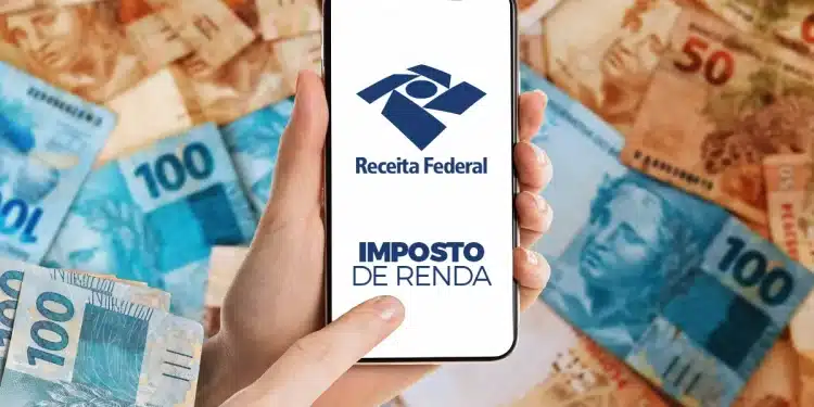Pessoa acessa o sistema do Imposto de Renda no celular com fundo de cédulas de real.