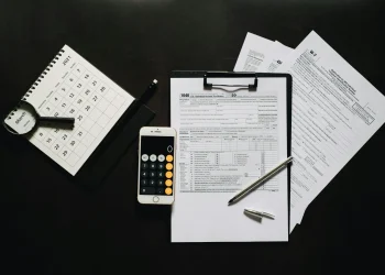 Documentos de imposto de renda, calculadora e calendário, ilustrando a isenção do IR até R$ 5 mil para 10 milhões de brasileiros.