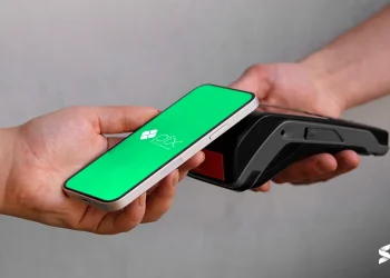 Pagamento via Pix sendo realizado com um smartphone em contato com uma maquininha de cartão.