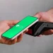 Pagamento via Pix sendo realizado com um smartphone em contato com uma maquininha de cartão.