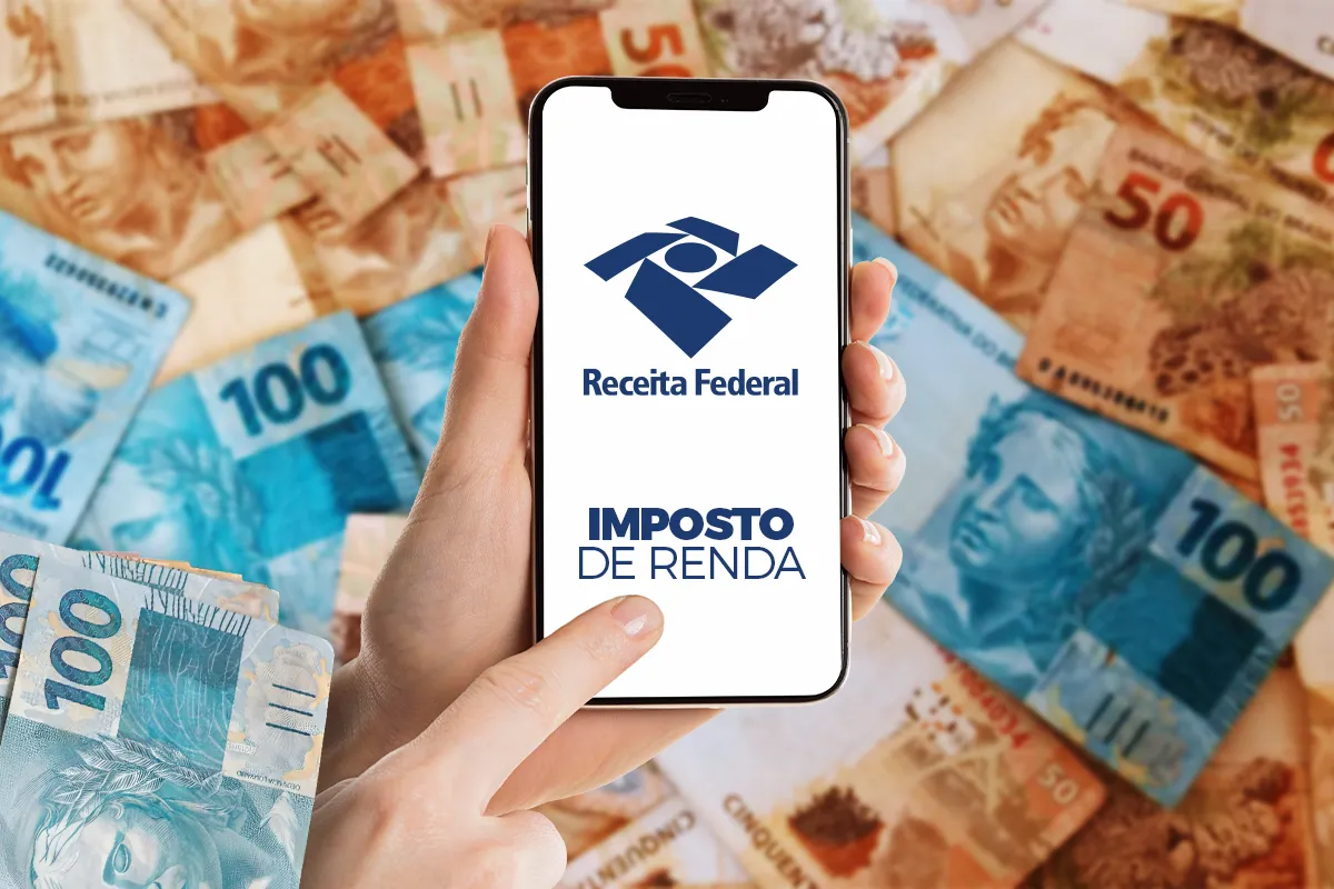 Pessoa segurando um celular com o logotipo da Receita Federal e a inscrição "Imposto de Renda", sobre um fundo de notas de real.