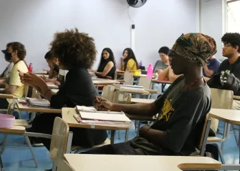 Alunos da rede pública em sala de aula, recebendo apoio para estudar, com foco no apoio financeiro para o Enem e vestibulares.
