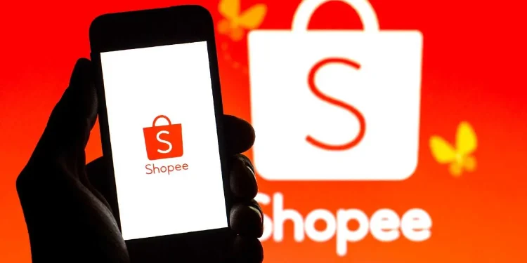 Logo da Shopee exibido em um celular, com fundo vermelho e a marca ao fundo, representando o trabalho na shopee