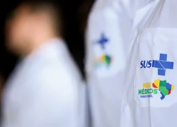 Jaleco branco com logotipo do SUS e do programa Mais Médicos bordado no bolso.
