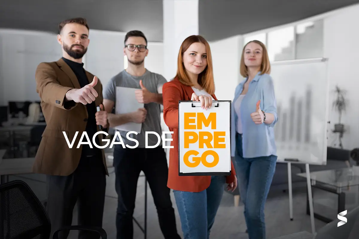 Imagem com quatro pessoas, três delas levantando o polegar e uma segurando um cartaz com a mensagem 'VAGAS DE EMPREGO'.