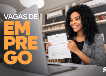Mulher sorrindo e segurando contrato com informações sobre vagas abertas na área de TI nas empresas TIM, Solar Coca-Cola, Grupo Boticário e Americanas.