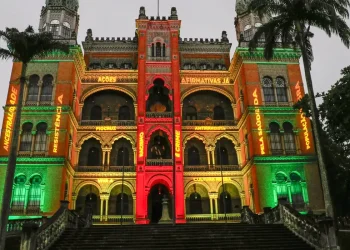 Prédio histórico da Fiocruz iluminado com projeções coloridas e frases institucionais