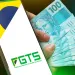 Celular exibindo o logo do FGTS ao lado de mãos segurando cédulas de 100 reais, representando o saque-aniversário do FGTS em 2025.