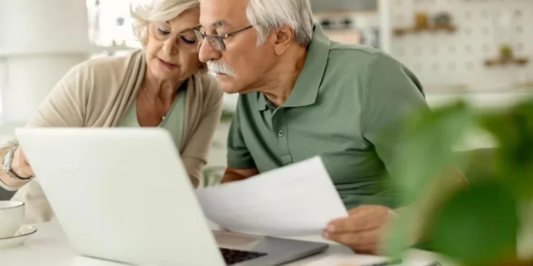 Casal de idosos planejando aposentadoria e analisando documentos.