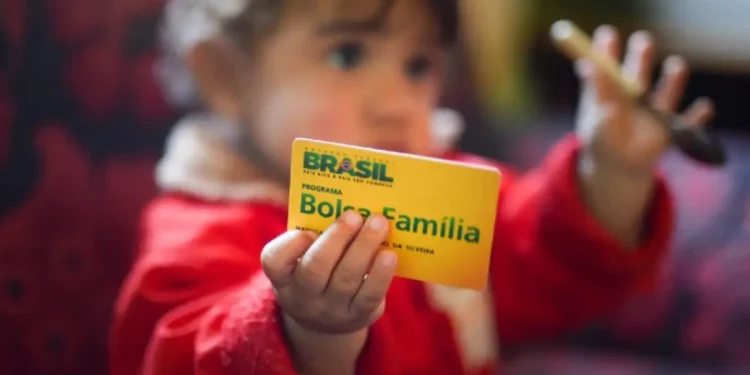 Criança segurando cartão do Bolsa Família, símbolo dos pagamentos sociais do programa em maio.