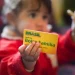 Criança segurando cartão do Bolsa Família, símbolo dos pagamentos sociais do programa em maio.