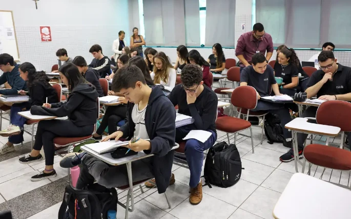 Estudantes concentrados fazendo provas em sala de aula, representando a preparação para o Enem 2025.