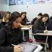 MEC anuncia benefício de R$ 200 mensais para estudantes de cursinhos populares; entenda 8 Estudantes concentrados em sala de aula, utilizando cadernos e tablets.