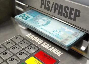 Cédulas de 100 reais saindo de um caixa eletrônico com a palavra PIS/PASEP visível