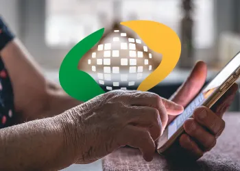 Imagem de uma mão mexendo no aplicativo do INSS.