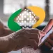 Imagem de uma mão mexendo no aplicativo do INSS.