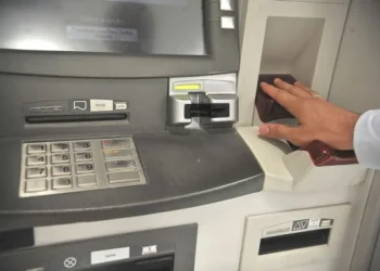 Pessoa utilizando biometria em caixa eletrônico para saque do FGTS.