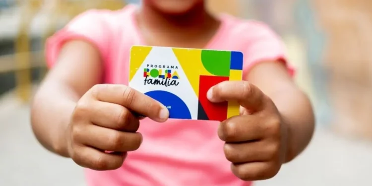 Cartão do Programa Bolsa Família sendo segurado por uma criança, com cores vibrantes e logo visível.