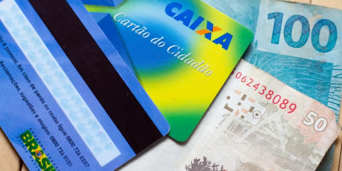 Cartão Cidadão da Caixa Econômica Federal com cédulas de 50 e 100 reais, simbolizando o acesso a benefícios sociais.