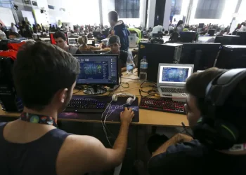 Alunos em ambiente tecnológico participando de curso prático com computadores