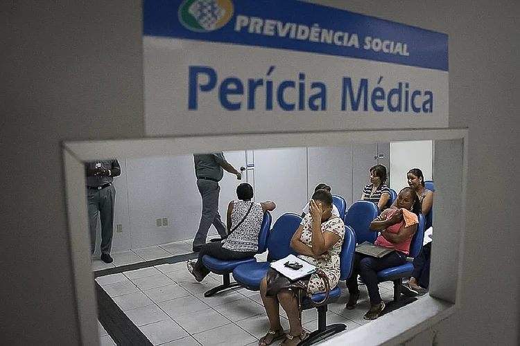 Pessoas aguardando atendimento médico em uma sala de espera da Previdência Social, com foco na necessidade de reforço para reduzir tempo de espera em perícia médica.