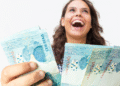 Mulher sorrindo com notas de 100 reais, representando apoio financeiro do programa Mães de Pernambuco 2025