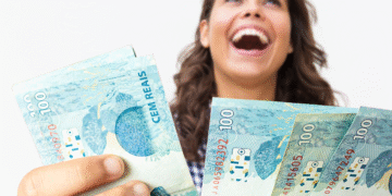 Mulher sorrindo com notas de 100 reais, representando apoio financeiro do programa Mães de Pernambuco 2025