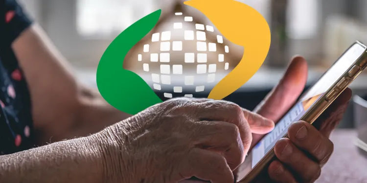 Mãos de idoso acessando comunicado do INSS pelo celular