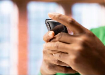 Pessoa usando smartphone para acessar aplicativo de renda extra