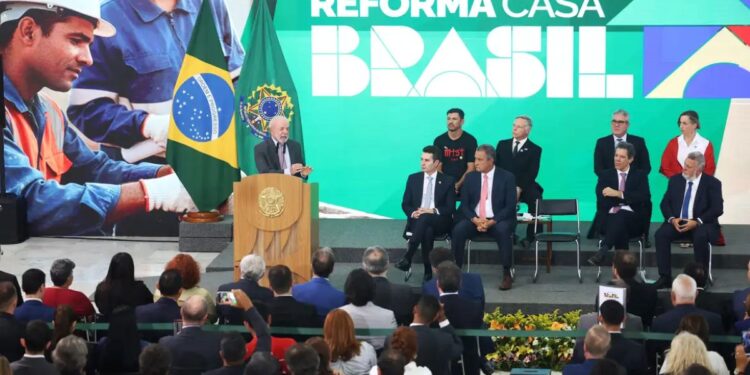 Crédito para reformar casa pela Caixa: como funciona o Reforma Casa Brasil e quem pode se inscrever 1 Presidente discursando no lançamento do programa Reforma Casa Brasil, com a bandeira do Brasil ao lado e painel exibindo trabalhadores da construção civil.