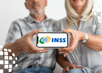 Casal de aposentados segurando celular com o logo do INSS, simbolizando o acesso à informação sobre o ressarcimento.