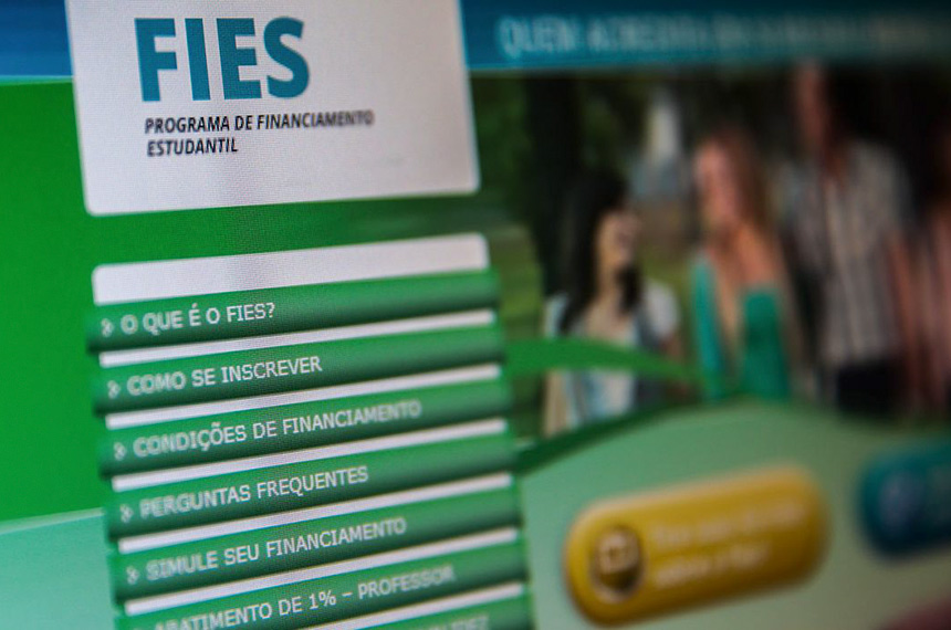 FIES: Condições Especiais e Perdão de Juros e Multas para Renegociação de Dívidas Tela de computador exibindo o logotipo "FIES - PROGRAMA DE FINANCIAMENTO ESTUDANTIL" com um menu de opções (O que é o FIES?, Como se inscrever, Condições de financiamento).